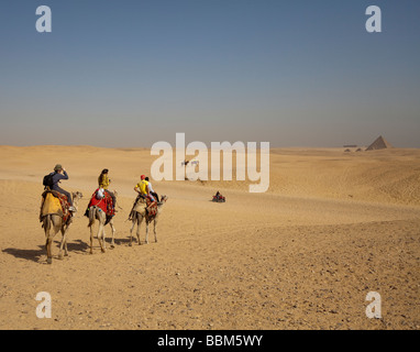 I turisti a cavallo di cammelli e ATV (dune buggy) sulla sabbia al Pyradmids, Giza, il Cairo, Egitto Foto Stock