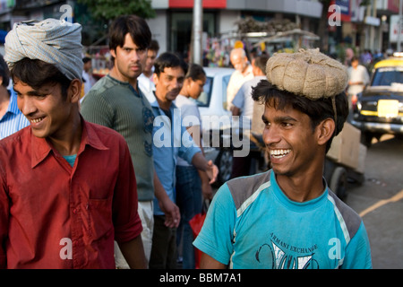 2 Indian Coolies rideva fuori mercato Crawford, Mumbai, India. Un 'Coolie' è un lavoratore che trasporta carichi pesanti. Foto Stock