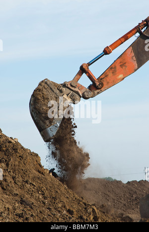 Un escavatore dumping una benna di sporcizia Foto Stock
