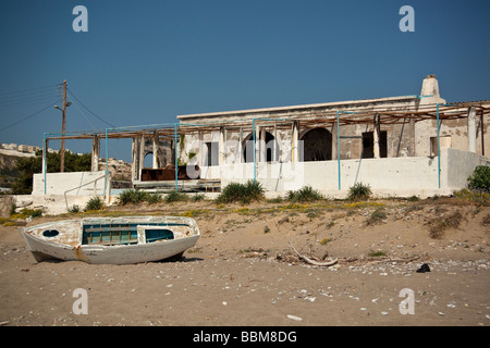 Un olocausto derelitti ristorante sul fronte spiaggia in Grecia con la barca, Kefalos, Kos Foto Stock