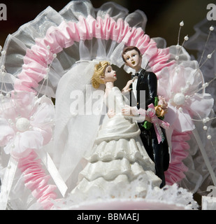 Coppie in viaggio di nozze figurine su una torta di nozze Foto Stock