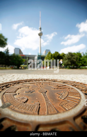 Fernsehturm torre della TV e un chiusino dalla Berliner Wasserbetriebe, Berlino servizi idrici a Berlino, Germania, Europa Foto Stock