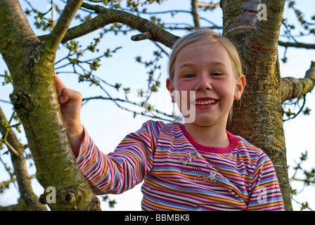 Ragazza 6 anni, ha scalato in un albero ciliegio Foto Stock