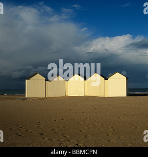 Cabine sulla spiaggia, sotto un cielo tempestoso in Normandia. La Francia. Foto Stock