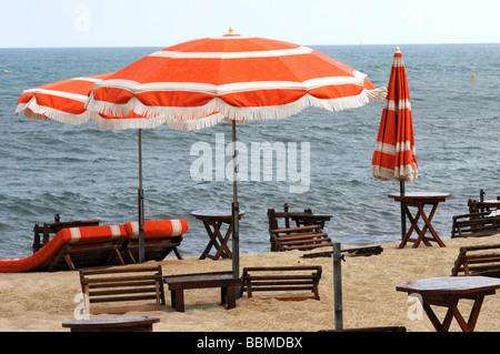 Rainy day presso la spiaggia con ombrellone e sedia a sdraio Foto Stock