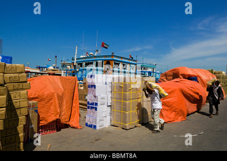 I lavoratori del porto di sharjah il trasporto di merci sulle barche Dhow Foto Stock