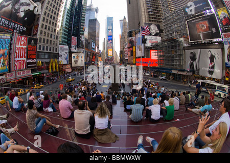 Le persone a rilassarsi sulle scale rosso dietro il TKTS booth a Times Square a New York Foto Stock