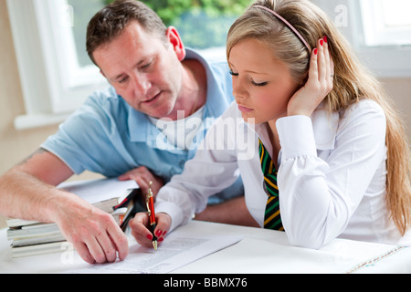 Padre aiutando la figlia con i compiti Foto Stock