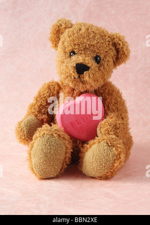 Orsacchiotto di peluche e cuore rosa con 'I Luv U' su di esso Foto Stock