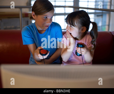 Due ragazze guardando un video gioco mentre a sorpresa Foto Stock