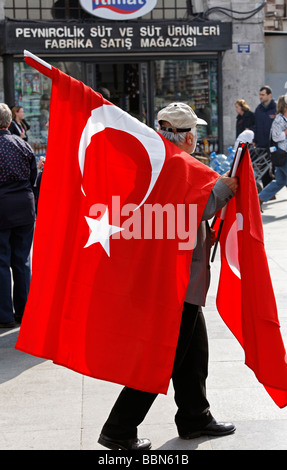 Venditore ambulante porta grande bagno turco bandiere nazionali, Istanbul, Turchia Foto Stock