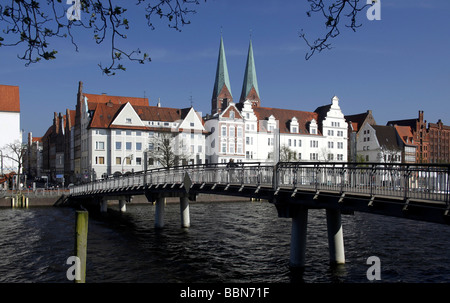 Hanseatic residenze e ponte pedonale attraverso il fiume Trave, città anseatica di Lubecca, Schleswig-Holstein, Germania, Europa Foto Stock