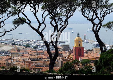 Vista della clocktower, tetti e sulla baia di Saint Tropez incorniciata da pini; in Costa Azzurra, Francia meridionale Foto Stock