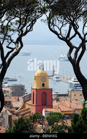 Vista della clocktower, tetti e sulla baia di Saint Tropez incorniciata da pini; in Costa Azzurra, Francia meridionale Foto Stock