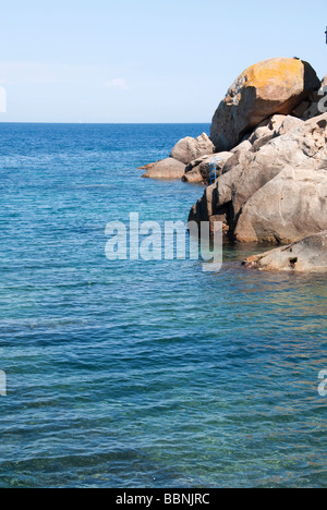 Le scale a pioli blu consentono nuotatori decend in mare al largo della costa di rocce a Isola del Giglio o Isola del Giglio fuori della costa toscana Foto Stock