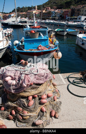 Una classica vecchia barca da pesca con reti e galleggia in Giglio Porto la luce di entrata per l'Isola del Giglio o Isola del Giglio Foto Stock