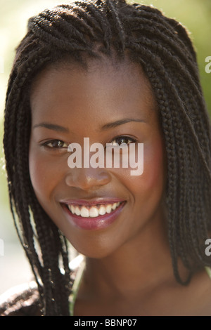Ritratto di una giovane donna africana all'aperto di sorridere alla cinepresa, primo piano Foto Stock