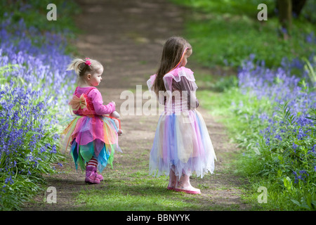 Due giovani bambini in abiti di fata godendo l'incanto di un bluebell riempito di legno in Inghilterra. Foto Stock