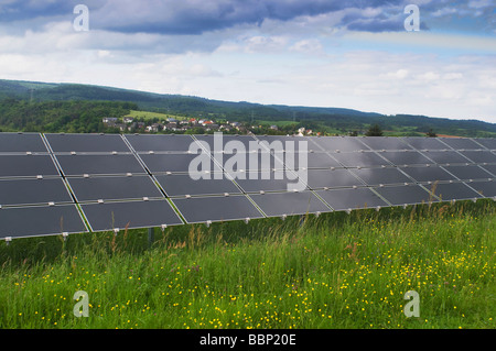 Centrale solare su un campo verde, impianto fotovoltaico, vista di una serie di diversi moduli Foto Stock