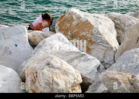 Gli amanti della spiaggia di MARINA DI CARRARA delimitata da un blocco di marmo bianco, mondo CAPITALE IN MARMO DI CARRARA, Toscana, Italia Foto Stock