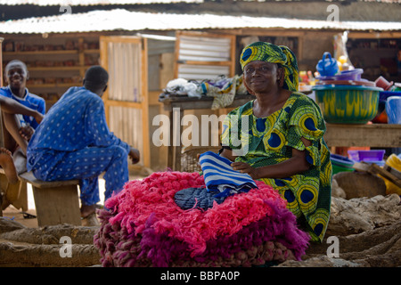 Una donna vende colorata a mano con stoffa a maglia ad Abuja, Nigeria. Foto Stock