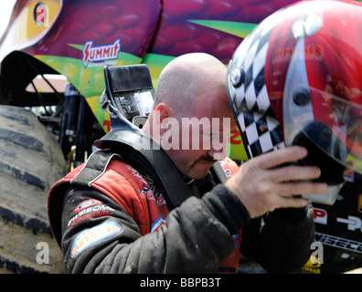 Monster Truck driver Larry nuotare, unità Snakebite, mette sul casco oltre il dispositivo Hans. Foto Stock