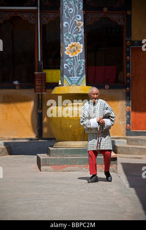 Uomo che prega tenendo la preghiera mulino in Tashi Dzong Chho, Thimphu Bhutan Asia Foto Stock