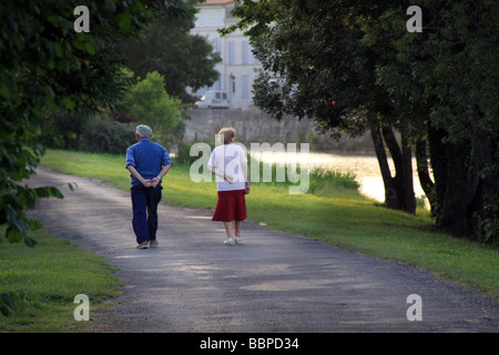 Pensionati anziani matura fate una passeggiata lungo le sponde del fiume al crepuscolo in Charente area della Francia. Foto Stock