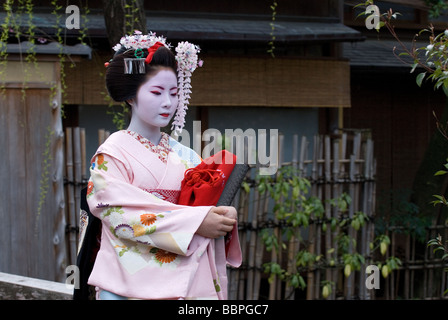 Un apprendista geisha o maiko, camminando lungo una stradina in Kyoto Shimbashi quartiere di Gion. Foto Stock