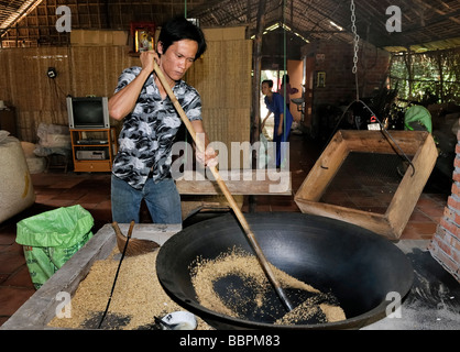 L'uomo la preparazione di riso soffiato, fabbrica dolciaria, Vinh Long, Delta del Mekong, Vietnam, sud-est asiatico Foto Stock