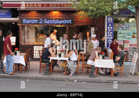 Istanbul Turchia turisti in un open air outdoor Cafe Restaurant lungo la Divanyolu Caddesi nell' area di Sultanahmet Foto Stock