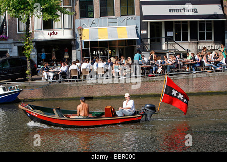 Barca con la bandiera con le tre croci, emblema della città di Amsterdam e il CAFE WALEM KEIZERSGRACHT, Paesi Bassi, Olanda Foto Stock