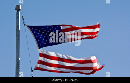 Bandiera americana strappata a metà su un palo di bandiera. Foto Stock