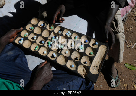 Uomini che giocano a Bao tradizionale gioco da tavolo in Malawi Foto Stock