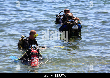 Quattro subacquei entrata in acqua, volare punto riserva acquatica una sponda popolare sito di immersione a Nelson Bay Port Stephens Australia Foto Stock