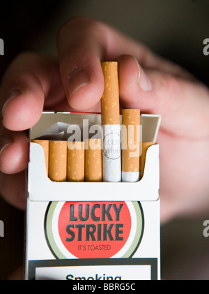 Un fumatore prende un colpo di fortuna sigaretta prodotta dalla British  American Tobacco a partire da un pacchetto Foto stock - Alamy