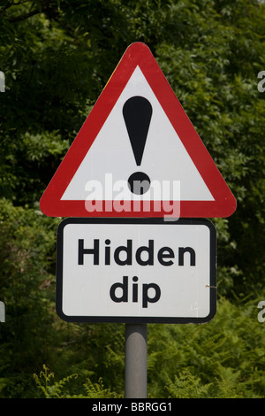 Cartello stradale con un triangolo rosso il punto esclamativo per Dip nascosti Foto Stock