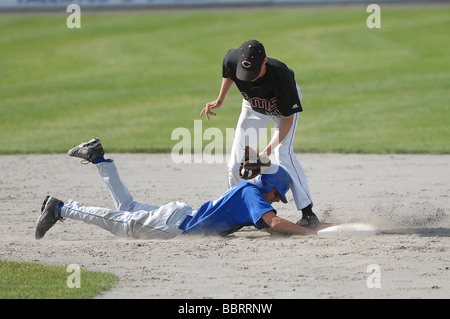 Una scuola di giocatore di baseball scorre nella seconda base durante una partita di New Haven Connecticut USA Foto Stock
