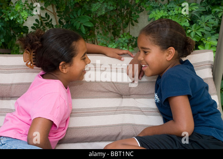 Multi diversità razziale razziale multiculturale cTwo sorelle 6-7 8-9 anno parlando di conversare in chat chat animata signor © Myrleen Pearson Foto Stock