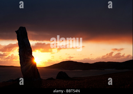 Mcleods pietra permanente sunset silhouette, guardando oltre il suono di Taransay, Isle of Harris, Ebridi Esterne, Scozia Foto Stock