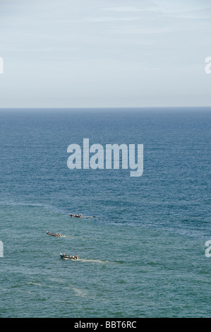 Barca da pesca accelerando in tutta l'acqua all'orizzonte a distanza del mare Arabico. Foto Stock