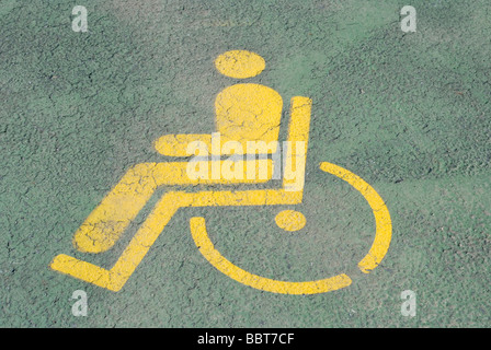 Dipinto di giallo simbolo di Handicap su uno spazio di parcheggio Foto Stock