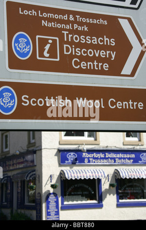 Villaggio di Aberfoyle, Scozia. Direzione turistica segni sulla strada principale del pittoresco Scottish Tourist villaggio di Aberfoyle. Foto Stock