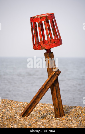 Una formazione di ruggine, dipinta di rosso marcatore groyne sulla spiaggia di Aldeburgh Foto Stock