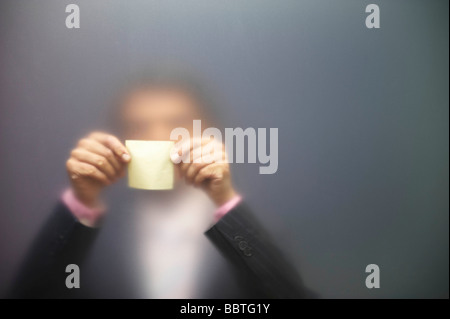 L'uomo sticking nota su schermo smerigliato Foto Stock