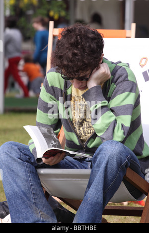 Hay Festival uomo leggendo un libro in una sedia a sdraio presso il book festival nel mese di maggio 2009 Foto Stock