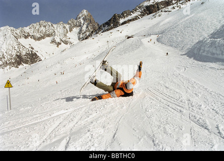 La laminazione del ragazzo in neve con uno scarpone da snowboard Foto Stock