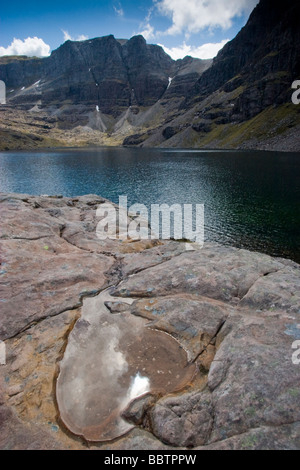 Triple contrafforte e corrie lochan, Ben Eighe, Torridon, con un cuore shaped pool in primo piano che riflette il sole Foto Stock