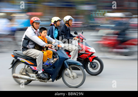 Padre e figlio su un ciclomotore, Hanoi, Vietnam del nord, sud-est asiatico Foto Stock