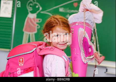 Ragazza il suo primo giorno di scuola tenendo un schultuete, scuola cono riempito con dolci e regali Foto Stock